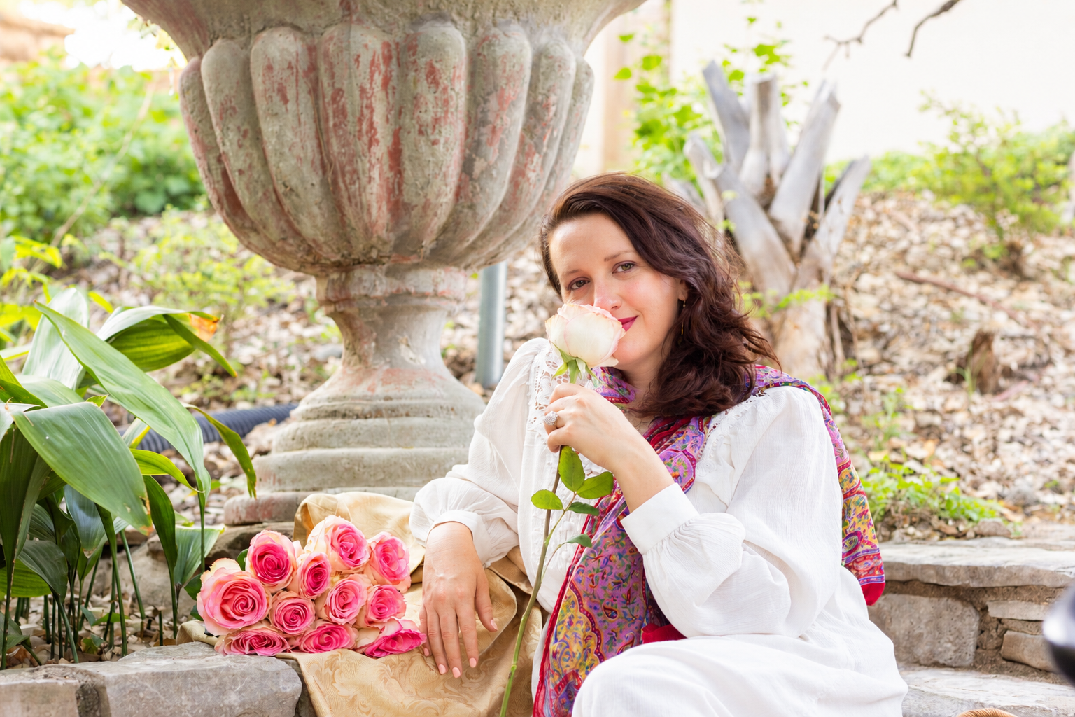 Scarlet Sanghavi smelling a rose in the garden